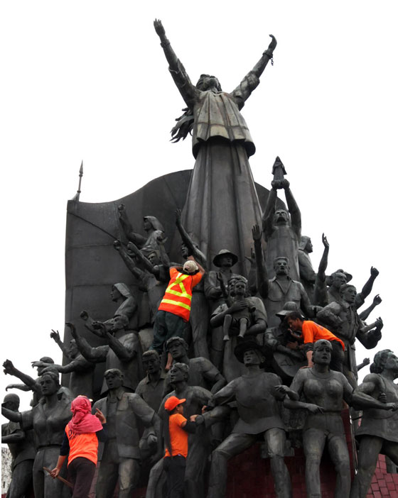 Workers scrub statues at the EDSA Monument days before the 29th anniversary of the peaceful People Power revolt that toppled strongman Ferdinand Marcos. Photo by Mike De Juan 