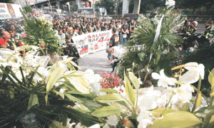 MEMORIAL  Hundreds of military bikers offer prayers and flowers at the main gate of the police headquarters for the 44 commandos killed in Maguindanao. Mourners continue to bring flowers and light candles at the gate, which have become a memorial of sorts for the fallen policemen. Photo by Miguel de Guzman