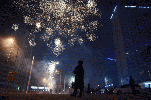 GREETING THE NEW YEAR People watches as fireworks explode over a street in Beijing early on Thursday. Millions of Chinese around the world are celebrating the Lunar New Year, which marks the beginning of the Year of the Sheep on Thursday. AFP PHOTO