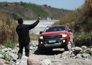 A spotter maneuvers the pickup truck using hand signals