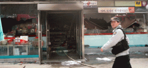 UNUSUAL SCENE A policeman walks outside the scene of a fatal shooting and arson attack at a convenience store in Sejong on Wednesday. AFP PHOTO