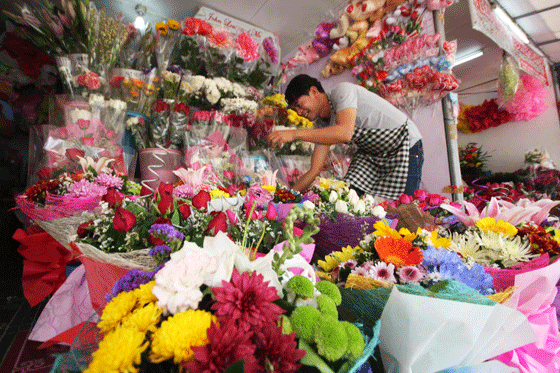SAY IT WITH FLOWERS  A vendor arranges flowers that he sells for P300 to P500 per bouquet at stall in Cubao, Quezon City, on Sunday as flower prices continue to rise with the approach of Valentine’s Day. PHOTO BY MIGUEL DE GUZMAN