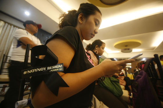 A woman uses her phone during the launch of the Noynoy Out Now! National Movement in Quezon City.PHOTO BY MIGUEL DE GUZMAN