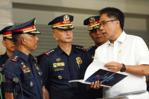 DEFECTIVE PLAN Interior Secretary Manuel Roxas 2nd (top right) speaks to PNP chief Leonardo Espina (center) and Director Benjamin Magalong (left) as he leafs through a copy of the final report of the PNP-Board of Inquiry which concluded that (mugshots from left) President Aquino, resigned PNP chief Alan Purisima and former Special Action Force commander Getulio Napeñas Jr. broke the Chain of Command when they kept Roxas and Espina out of the loop in the botched Oplan Exodus. Photo by Miguel de Guzman 