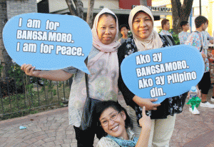 GIVE PEACE A CHANCE Women participating in the ceremony marking the 4th anniversary of the i nfamous Jabidah massacre which sparked the Moro rebellion hold ‘quote bubbles’ reflecting their position pushing for the passage of the proposed Bangsamoro Basic Law. PHOTO BY MELYN ACOSTA