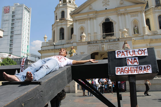 An activist reprises the crucifixion of christ at the Plaza Miranda fronting the Quiapo church in Manila as a militant group uses the story of the passion and death of Jesus to depict the plight of the poor people.  Photo by Melyn Acosta 