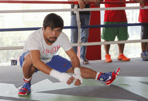 Manny Pacquaio performs leg stretches during training. AFP PHOTO