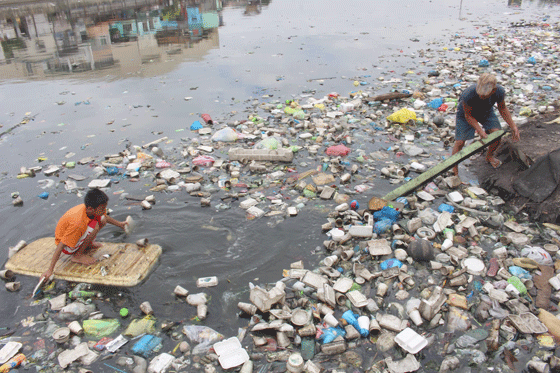 A boy and his father collect plastic cups at a garbage-filled river in Manila. The day’s collection will then be sold to a nearby junk shop. The Philippines has been found to be one of the top contributors to ocean pollution. PHOTO BY RUY L. MARTINEZ