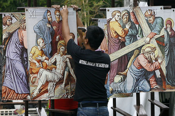 A worker installs Stations of the Cross “standees” that depict the suffering of Jesus Christ at the National Shrine of the Sacred Heart in Makati City as the country prepares its solemn observance of Holy Week that starts on March 29, Palm Sunday. PHOTO BY MIGUEL DE GUZMAN