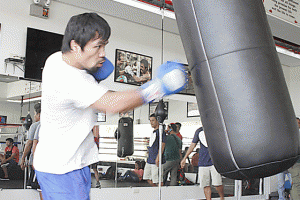 Manny Pacquiao hits the heavy bag during training. AFP FILE PHOTO