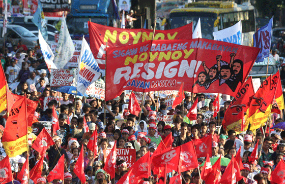 Workers and members of women’s groups carry huge banners calling on President Benigno Aquino 3rd to step down during a rally in Manila. PHOTO BY RENE H. DILAN