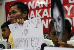 sAVe ouR mom mark darrel (right) and mark daniel (left) hold placards appealing to the government to save their mother, mary Jane veloso, from death. mary Jane is facing execution in indonesia for drug smuggling. Photo by Mike De Juan 