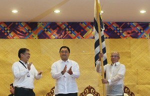 SIGH OF RELIEF A jubilant John Phillip ‘Sunny’ Sevilla applauds with gusto as his successor, newly-minted Customs Commissioner Alberto Lina, holds aloft the agency’s colors during Friday’s turnover ceremony. Also in photo is Finance Secretary Cesar Purisima. Photo  by Rene Dilan