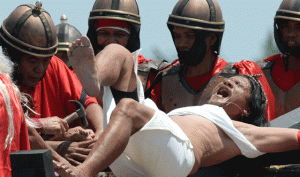 CRYING FOR FORGIVENESS Penitent Ruben Enage wails in pain as he is nailed to a cross by residents wearing costumes of Roman centurions during the observance of Lent in the village of Cutud, San Fernando City in Pampanga. AFP PHOTO