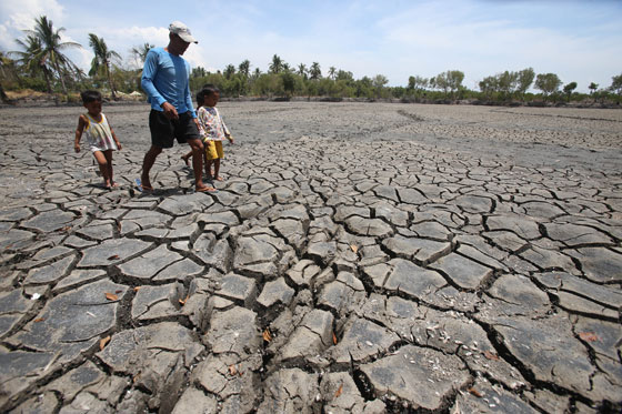 A man and his two children walk on a parched spot in in Noveleta, Cavite where schools of fish used to thrive. Metereologists say temperatures are rising further as the El Niño phenomenon strengthens. They said the phenomenon would last until the “ber” months in the Philippines. The Department of Agriculture said 47,000 farmers may have lost a total of P2.19 billion to the dry spell.  PHOTO BY RENE H. DILAN 