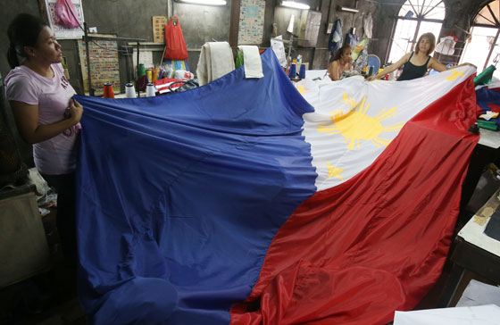Seamstresses unfurl a giant flag that would be put on display on Thursday, the first day of the National Flag Day celebration. It was on May 28, 1898 that Philippine flag was first unfurled after the Philippine Revolutionary Army defeated Spanish forces in the Battle at Alapan in Imus, Cavite. Executive Order 179, issued by President Fidel Ramos, encourages Filipinos to display the Philippine flag throughout this period.  PHOTO BY RENE H. DILAN 