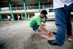  A worker on Friday marks with red paint a spot at the quadrangle of Barangka elementary school in Marikina City (Metro Manila or National Capital region) where, according to the Philippine Institute of Volcanology and seismology (Phivolcs),  the West Valley Fault passes through. Phivolcs said movements in the fault could trigger a strong earthquake in the region and nearby areas. PhOtO BY MIGUEL DE GUZMAN 