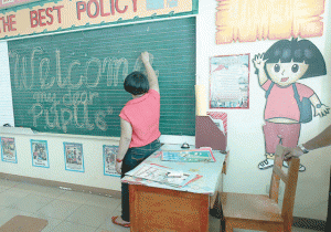 READY FOR THE BIG DAY Glen Talosig, a teacher at the Senator Ninoy Aquino school in Tondo, Manila, writes a message for the students who will fill her classroom today. PHOTO BY RENE H. DILAN