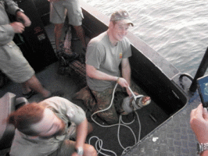 In this handout photo taken on April 15,from the Parks and Wildlife Commission Northern Territory and released on May 16 shows Britain's Prince Harry in Australia's Northern Territory sitting on a 3.1 meter crocodile in Darwin Harbor. Harry spent a month Down Under with the Australian Army, an experience which involved learning bush survival skills, flying helicopters and working with elite SAS commandos. AFP PHOTO