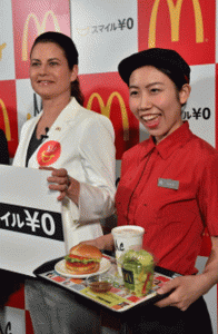 McDonald's Japan president Sarah Casanova (left) and an employee displays the new menu 