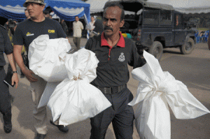 GRIM HARVEST  A Malaysian policeman carries human skeletal remains inside plastic bags exhumed from graves following the discovery of numerous grave sites and detention camps near the Malaysia-Thailand border in Wang Kelian on May 25, 2015. Malaysian police said May 25 they had found 139 grave sites and 28 abandoned detention camps used by people-smugglers and capable of housing hundreds, laying bare the grim extent of the region’s migrant crisis. AFP PHOTO / MOHD RASFAN