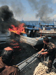 PUNISHMENT Indonesian Maritime Affairs and Fisheries Ministry officials destroy a Vietnamese vessel on Datuk Island in Mempawah in West Kalimantan on Wednesday. AFP PHOTO