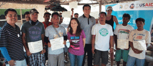 Steele (center) hands over the certificate of completion to seaweed farmers of Barangay Galoc who participated in a USAid-organized training on proper farming techniques and aquaculture practices to ensure the sustainability of the industry in the province