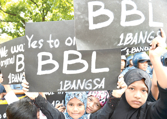 Children hoist placards supporting the passage of the proposed Bangsamoro Basic Law during a rally in front of the House of Representatives in Quezon City on Monday as the ad hoc committee tasked to review the measure convened to put the bill to a vote. AFP PHOTO