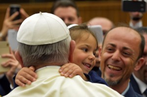  A little girl embraces pope Francis during a meeting with families of policemen fallen on duty at the Vatican. AFP PHOTO 