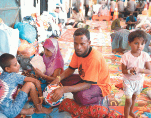 HARD LIFE In this photo taken on May 18, 2015, rescued Rohingya migrant from Myanmar, Mohammad Amih (C), sits with other survivors at the port in Langsa in Aceh. Rohingya and Bangladeshi migrants on board a foundering vessel off Indonesia fought with axes, knives and metal bars in vicious clashes that left at least 100 dead, survivors said as they recovered from their ordeal.  AFP PHOTO