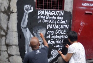 Artists collaborate on a protest piece they painted on the wall of the Kentex Manufacturing Corp. compound in Valenzuela City. PHOTO BY MIKE DE JUAN