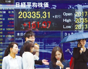 Pedestrians pass before a share price  board in Tokyo on Monday. Japan’s share prices rose 161.07 points to close at 20,335.31 points at the morning session of the Tokyo Stock Exchange, as Greece presented its creditors with new proposals to reform its bailout, fueling hopes it will avert a default and a possible exit from the Eurozone. AFP PHoto 