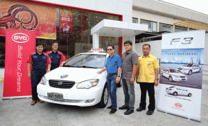 Officials of Solar Transport and Automotive Resources Corporation and World Transport stand beside the BY D F3 taxi model that has a 1.5-liter engine that is Euro 4 compliant.  