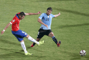 Chile’s defender Mauricio Isla shoots to score against Uruguay during their 2015 Copa America football championship quarterfinal match, in Santiago, on June 24, 2015. AFP PHOTO