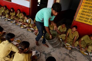 A man serves lunch, organized by the non-profit Akshaya Patra Foundation, to schoolgirls at Chaumuha Primary School on the outskirts of Vrindavan. Churning out 1.2 tonnes of curry in under an hour, women stirring vats in the spotlessly clean, high-tech kitchen are hoping to erase the shocking reputation of India's free school lunch scheme. AFP PHOTO