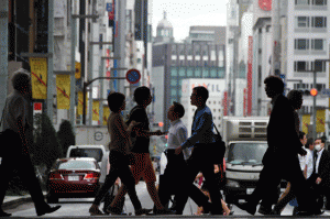 Shoppers cross a street in the Ginza shopping district in central Tokyo on Friday. Japanese inflation remained tepid while spending rose after 13 months of falls, official data showed.  AFP PHOTO