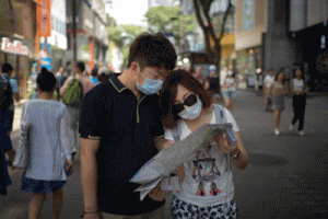 Tourists wearing face masks look at a map as they stand in the popular Myeongdong shopping area in Seoul. The Korea Tourism Organisation (KTO) reported that around 7,000 tourists -- mostly from China and Taiwan -- had cancelled planned group trips to South Korea, citing the MERS outbreak as the main reason, a KTO spokesman said. AFP PHOTO