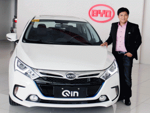 Mark Andew Tieng, managing director of Solar Transport and Automotive Resources Corporation, stands beside the BYD Qin hybrid sports sedan. 