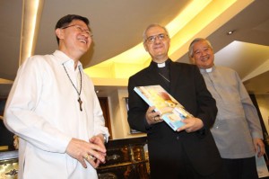 apostolic nuncio to the Philippines Fr. Giuseppe Pinto (center) shows a copy of the newly launched ‘Pope Francis@uST’ coffee table book to cardinal luis antonio Tagle (left) while bishop Socrates villegas looks on. PhOtO By rUy l. MartineZ 