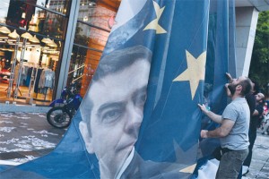 Protesters take down a huge banner bearing a picture of Greek Prime Minister Alexis Tsipras on a European Union flag from the ministry of finance in Athens as they end the occupation of the building on Thursday (Friday in Manila). The Greek government on Thursday said it would “intensify” efforts to resolve differences with its EU-IMF creditors to reach a deal that would give the country desperately needed bailout funds.  AFP PHOTO