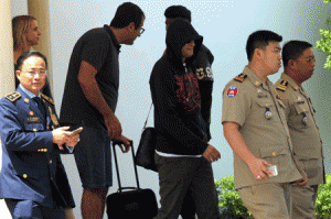 NEW HOME  A refugee (3rd R) held under Australian custody in the Central Pacific island of Nauru is escorted by Cambodian police following his arrival at the Phnom Penh International airport on June 4, 2015. Cambodia received its first batch of asylum seekers from Australian custody on June 4 as part of a controversial deal between the two countries that has triggered widespread international criticism. AFP PHOTO