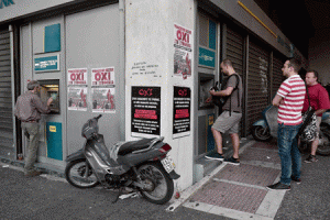 UNCERTAIN FUTURE  People withdraw money from a National Bank ATM in central Athens on June 29, 2015, as posters calling for a “No” vote in the forthcoming referendum on bailout conditions set by the country’s creditors are displayed on the walls nearby. Some 17,000 people took to the streets of Athens and Thessaloniki to say ‘No’ to the latest offer of a bailout deal Monday, accusing Greece’s international creditors of blackmail. AFP PHOTO