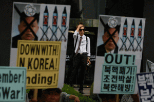 NOT FANS OF MR. KIM  A man watches as a group of anti-North Korea activists stage a rally in Seoul on June 25, 2015. South Korea is marking the 65th anniversary of the outbreak of the Korean War. AFP PHOTO