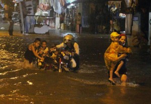  A family crosses kneedeep flood along Air Force Road in Barangay Holy Spirit in Quezon City. Photo By Ruy L. Martinez