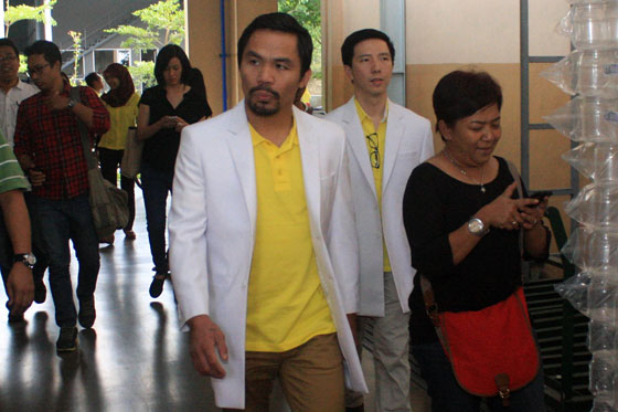 Filipino boxing champion Manny Pacquiao (C) visits a private indonesian medicinal laboratory plant in semarang, central Java island. He will visit filipino maid Mary Jane Veloso on death row in indonesia today ahead of a meeting with indonesian President Joko widodo, where he plans to raise her plight.  AFP PHOTO 