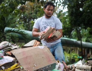 GONE IN ONE SWEEP  a man gathers what remains of the books and educational materials and furniture after floods inundated the Bitalag integrated school in Bacnotan, La Union. Photo by Lester A. Cardinez 