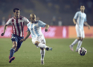 Argentina’s midfielder Javier Mascherano (center) kicks the ball marked by Paraguay’s forward Nelson Haedo Valdez during their Copa America semifinal football match in Concepcion, Chile on June 30, 2015. AFP PHOTO