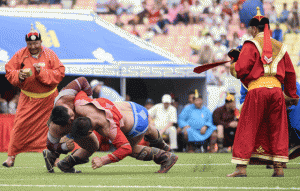 Mongolian wrestler Enkhtuvshingiin Oyunbold (second left) defeating an opponent in the seventh round during the National Naadam Festival at the Central Stadium in Ulan Bator. AFP PHOTO