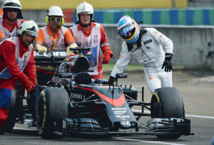 McLaren Honda’s Spanish driver Fernando Alonso (right) is helped by staff pushing his car after a trouble on the track during the qualifying session in Budapest on the eve of the Hungarian Formula One Grand Prix.  AFP PHOTO