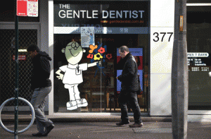 DIRTY DENTISTS?  Pedestrians walk past a Gentle Dentist clinic in Sydney on July 2, 2015, one of four surgeries that are accused of poor cleaning and equipment sterilization practices leading to up to 11,000 Australian dental patients being urged to see their doctors over fears they may have been exposed to HIV and hepatitis. AFP PHOTO